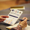 A close up of someone at a table looking at a conference brochure