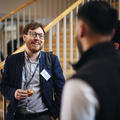 A man laughing and networking with fellow conference attendees