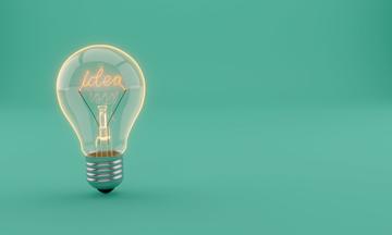 A lightbulb on a plain blue background with the word 'idea' spelt out as filament