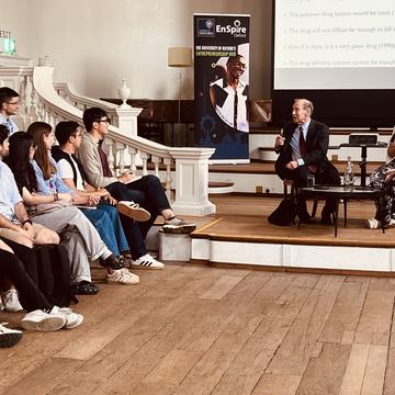 Speakers sat in front of an audience talking at an event