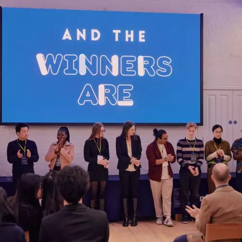 A row of early stage entrepreneurs pitching to an audience