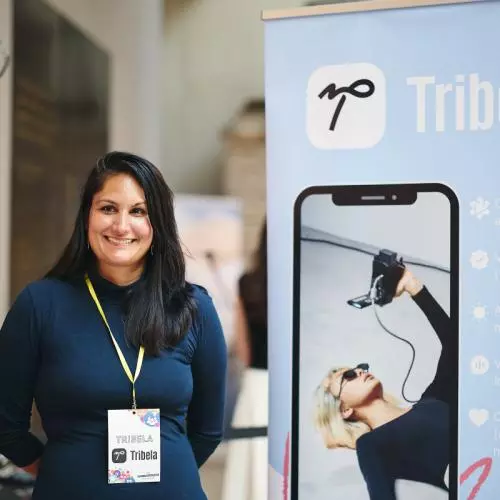 a startup founder smiling at their stand