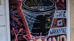 A chalk board sign with a coffee cup illustration and Common Ground typography