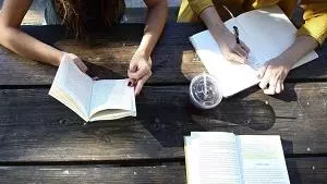 Birds eye view of three students working at a table with open books