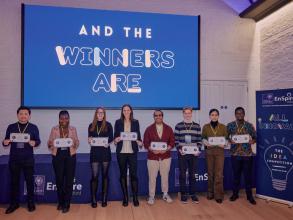 A group of students standing smiling with cheque prizes