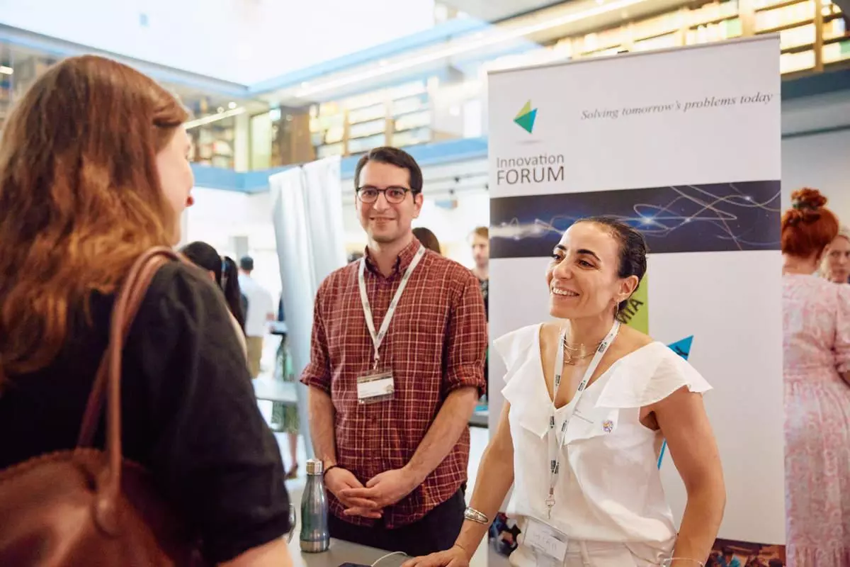 Two team members from the Innovation Forum talking at an event at their stand