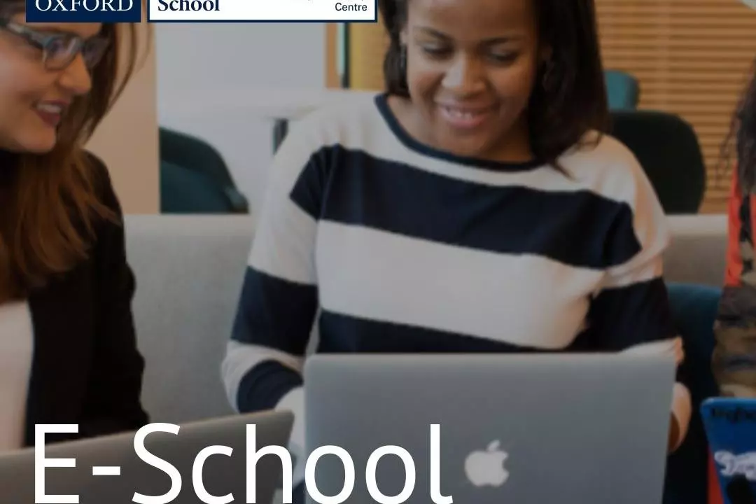 Two women looking at a laptop smiling