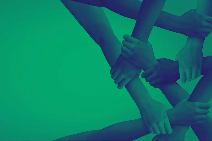 A photo of multiple hands holding onto each other to form a structure