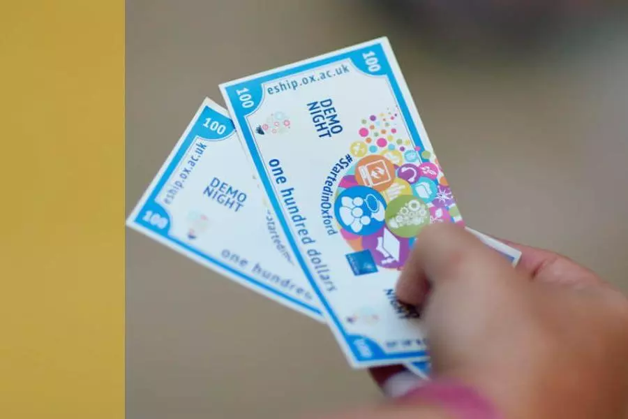 Someone holding #StartedinOxford Demo Night dollars